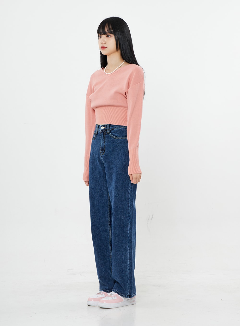 Basic Long Denim Pants BS28 in mid-blue, side full-length on model, straight-fit wide-leg high-rise cotton denim showing leg width and length, pink crop knit and sneakers.