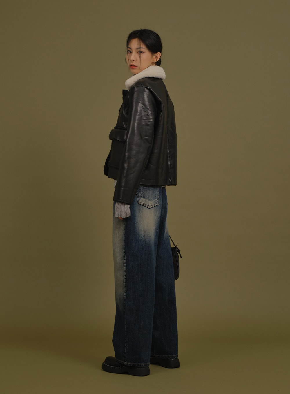 Washed Wide Denim Pants in blue, three-quarter back view on model, wide leg length and back pocket detail visible, styled with leather jacket and grey ribbed knit.