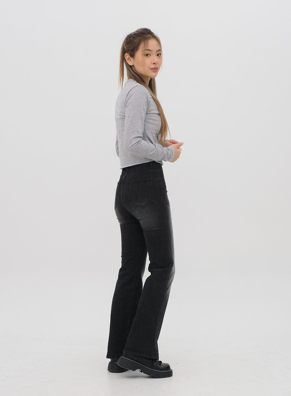 Bootcut Jeans M4 in black gradation wash, side full-length view on model, bootcut flare silhouette from hip to hem clearly shown, high waist, rear pocket visible.