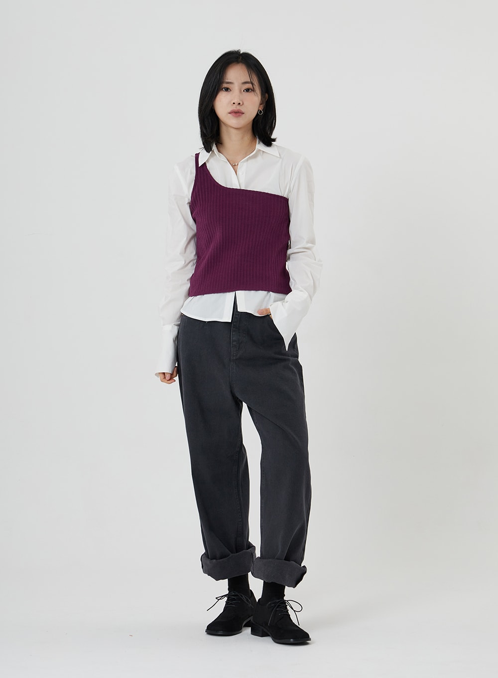 Maxi Denim Pants ON23 in charcoal grey, full-body front shot on model, relaxed wide-leg silhouette with rolled hem, styled with white shirt, purple ribbed vest, and black lace-up shoes.