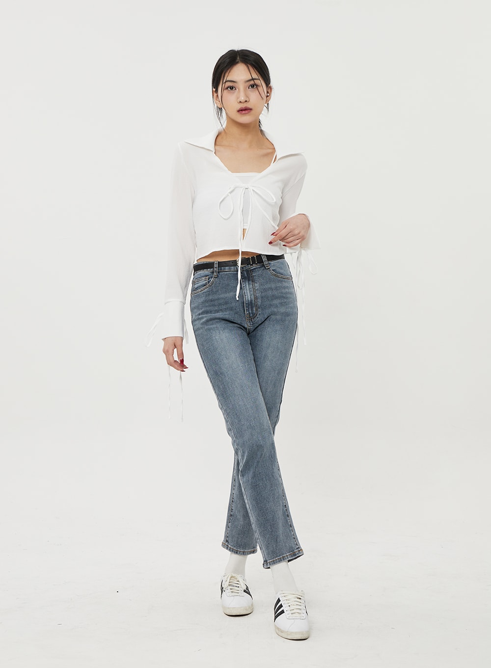 Straight Leg Ankle Jeans BF316 in mid-blue wash, front full-body on model, high-rise waistband with belt, slim straight leg, ankle length, worn with white tie-front top and sneakers.