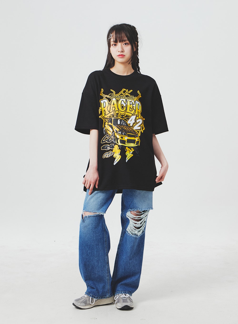 Ripped Knee Blue Jeans BA307 in blue, full-body front shot on model, wide-leg silhouette with dual knee rips, styled with oversized black racer graphic tee and silver chunky sneakers.
