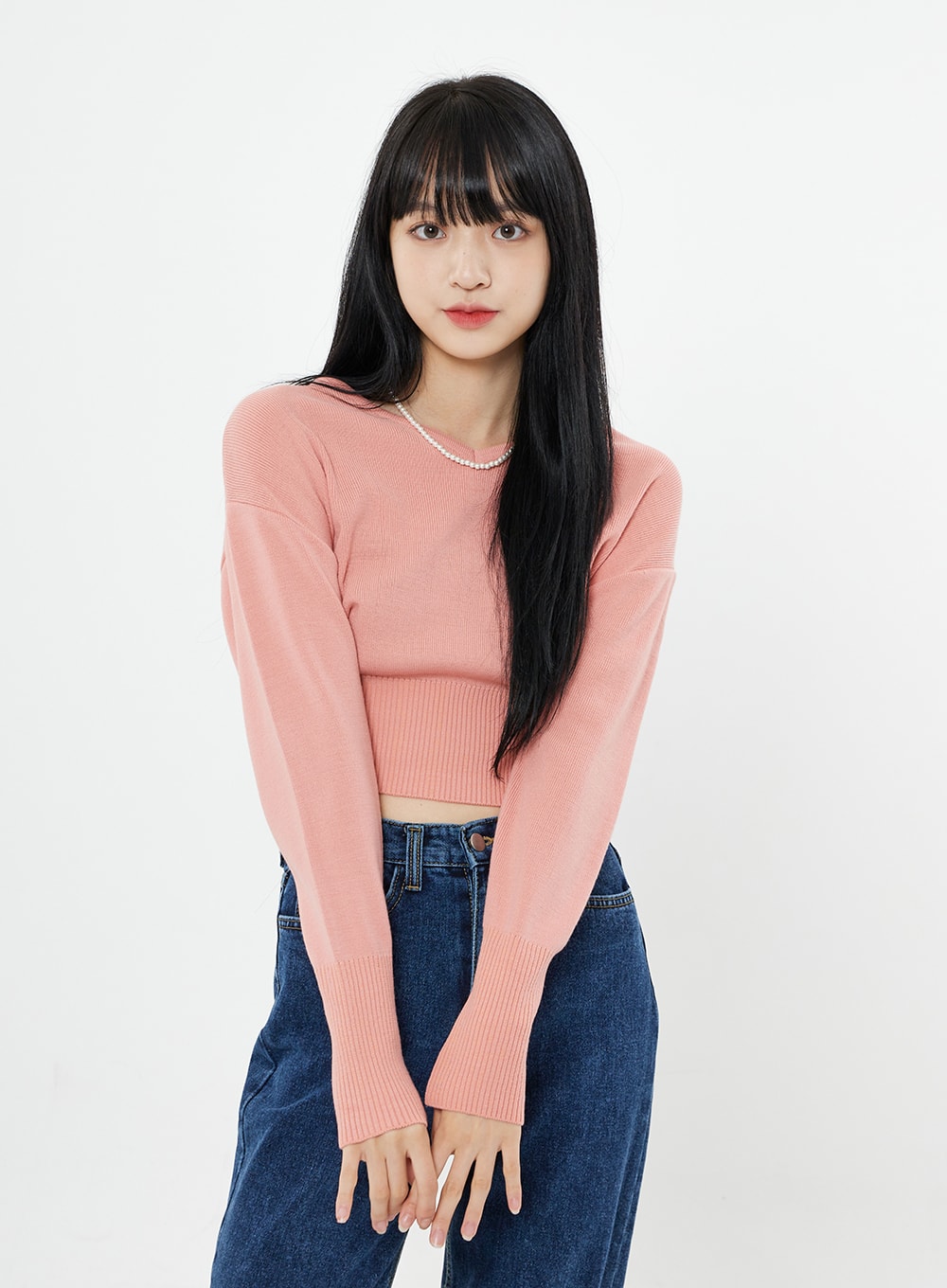 Basic Long Denim Pants BS28 in mid-blue, front upper-body close-up on model leaning slightly forward, high-rise waistband visible, straight-fit cotton denim, pink crop sweater.