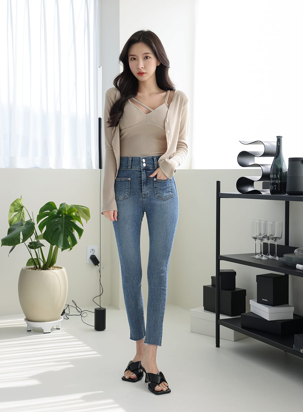 LEWKIN Double Button Raw Hem Skinny Jeans IA11 in mid blue denim, full-length front view on model, high-rise double-button closure, patch pockets, raw hem ankle, styled with beige cardigan and mule sandals.