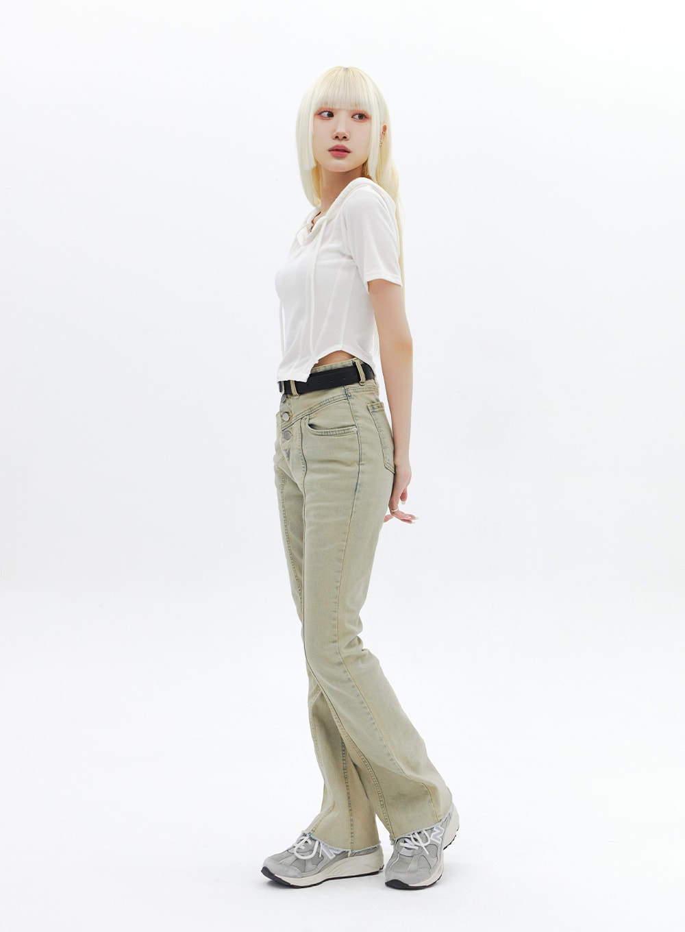 Beige Wash Bootcut Jeans BA320 in beige, three-quarter side view on model looking over shoulder, high-rise fit with center seam and slight bootcut flare, paired with white crop tee and black belt.