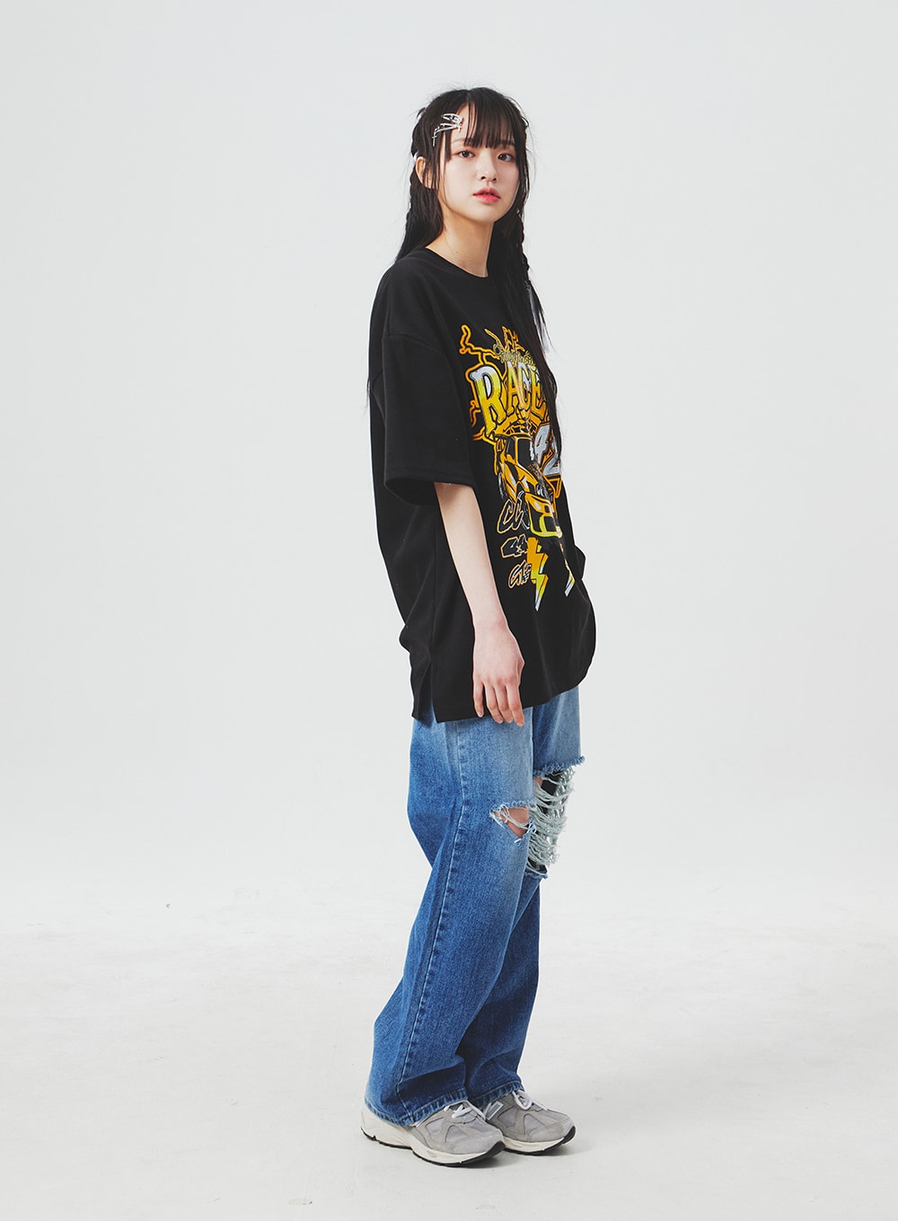 Ripped Knee Blue Jeans BA307 in blue, full-body side profile on model, wide-leg high-rise denim showing large right-knee rip detail, paired with black oversized tee and sneakers.