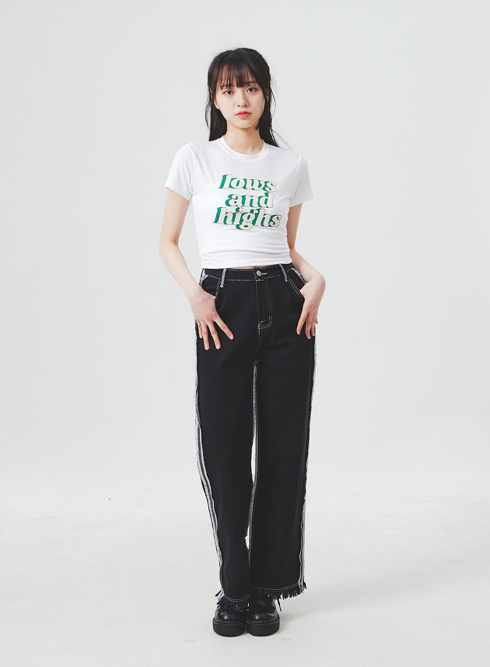Stitch Detail Jeans BA307 in black, front full-body shot on model hands-in-pockets pose, wide-fit high-waist cotton denim with contrast stitch side seams and frayed fringe hem.