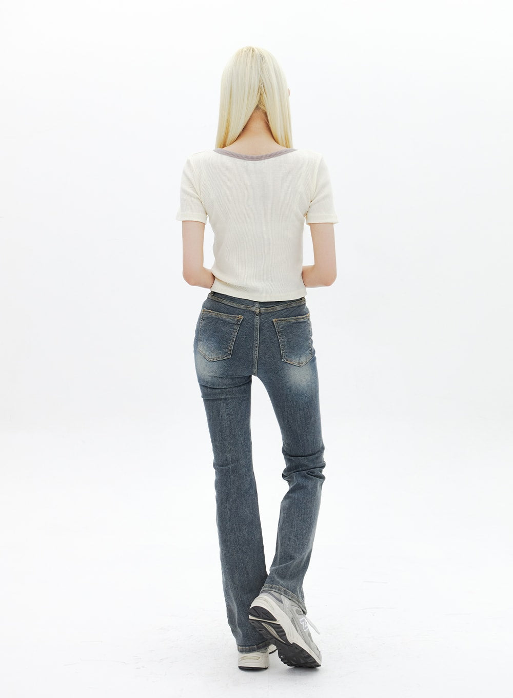Dark Wash Bootcut Jeans BA320 in dark blue, full-length back view on model, back patch pockets with washed fading and bootcut flare from knee, paired with white crop tee and sneakers.