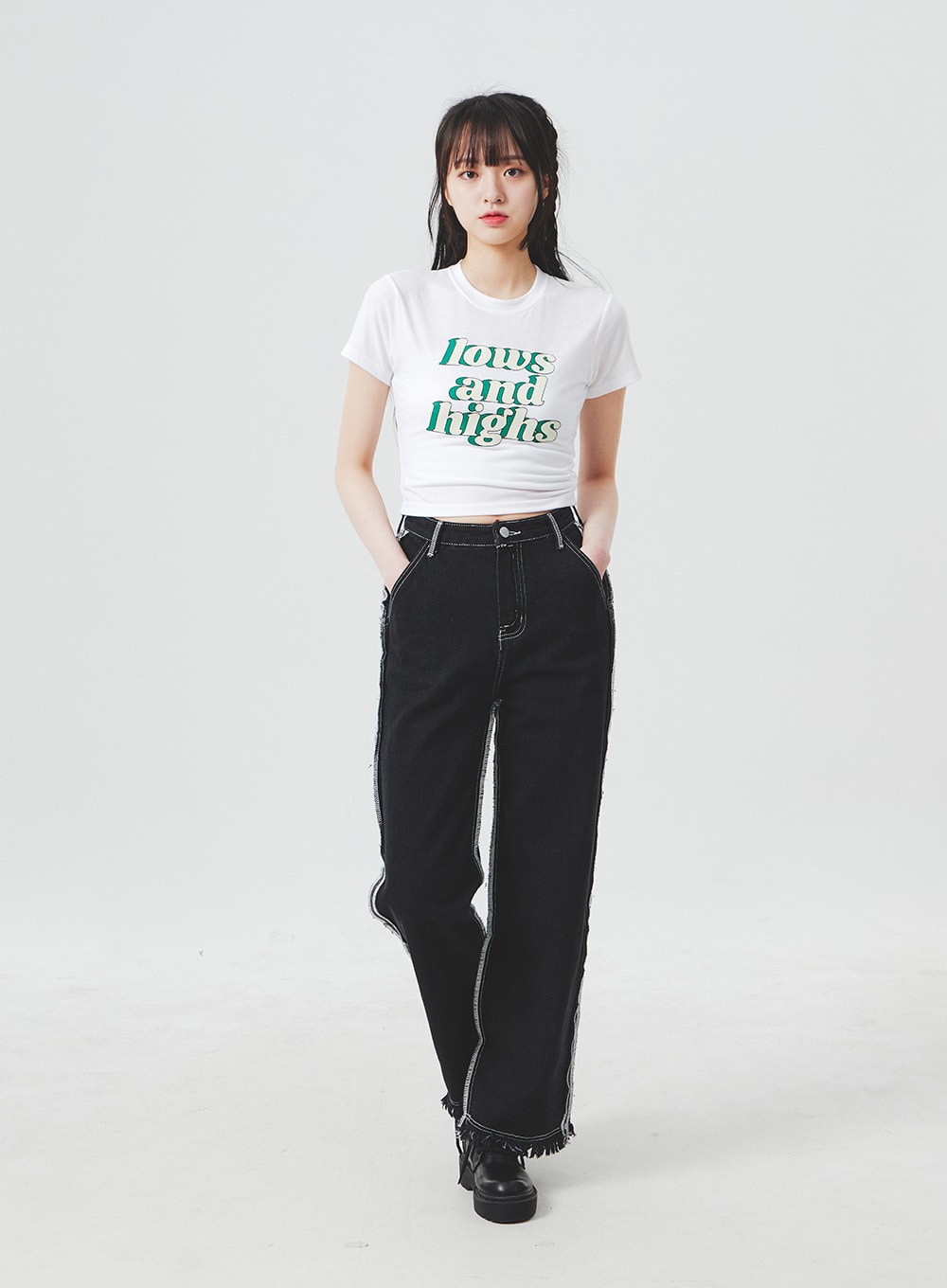 Stitch Detail Jeans BA307 in black, full-length walking pose on model, wide-fit casual denim with side contrast stitch stripes and frayed fringe hem, paired with white graphic crop tee.