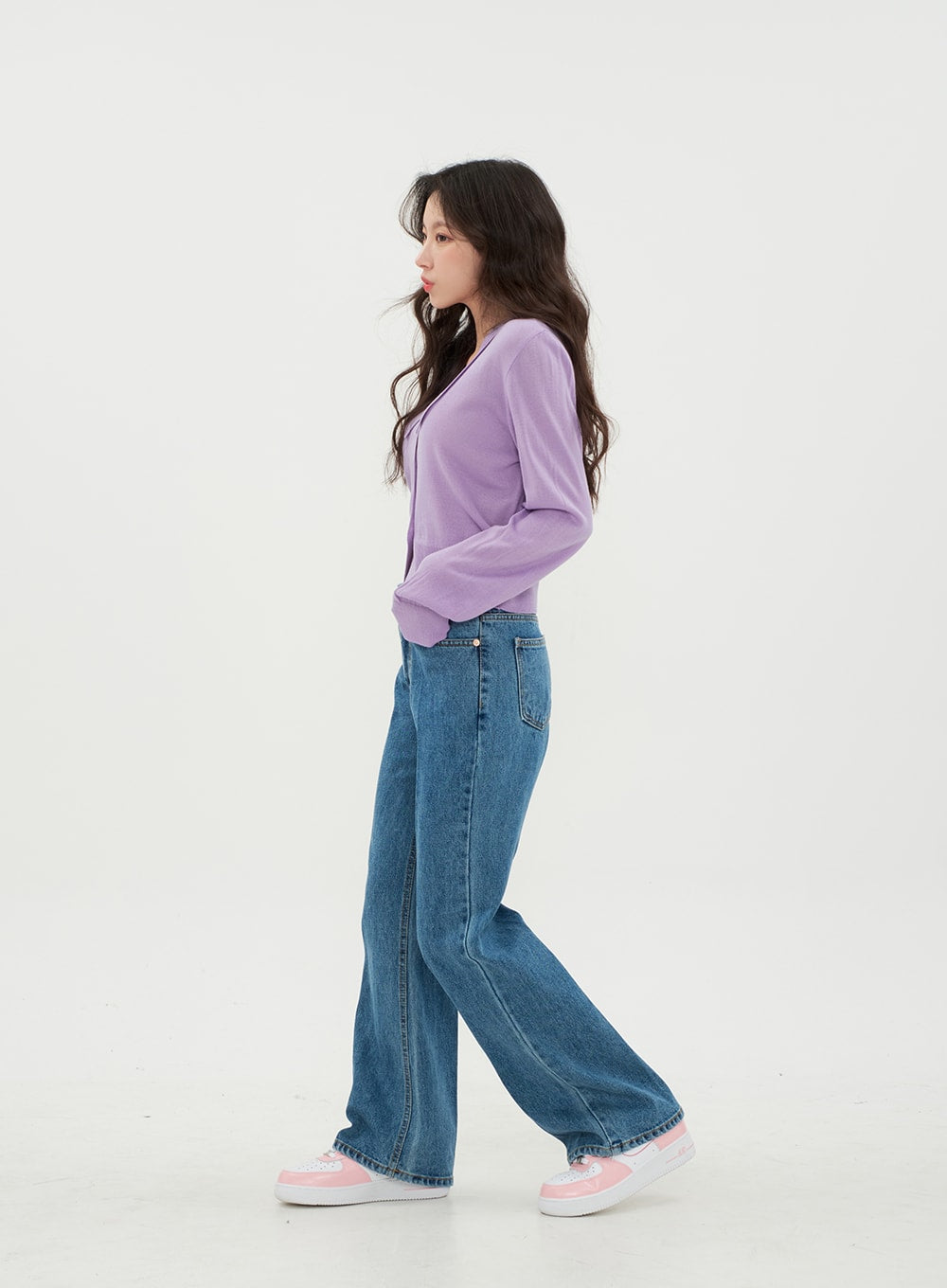 Semi Wide Jeans BM21 in mid-blue denim, side profile full-body on model walking, wide-leg cotton denim revealing silhouette length and straight side seam, paired with purple cropped knit.