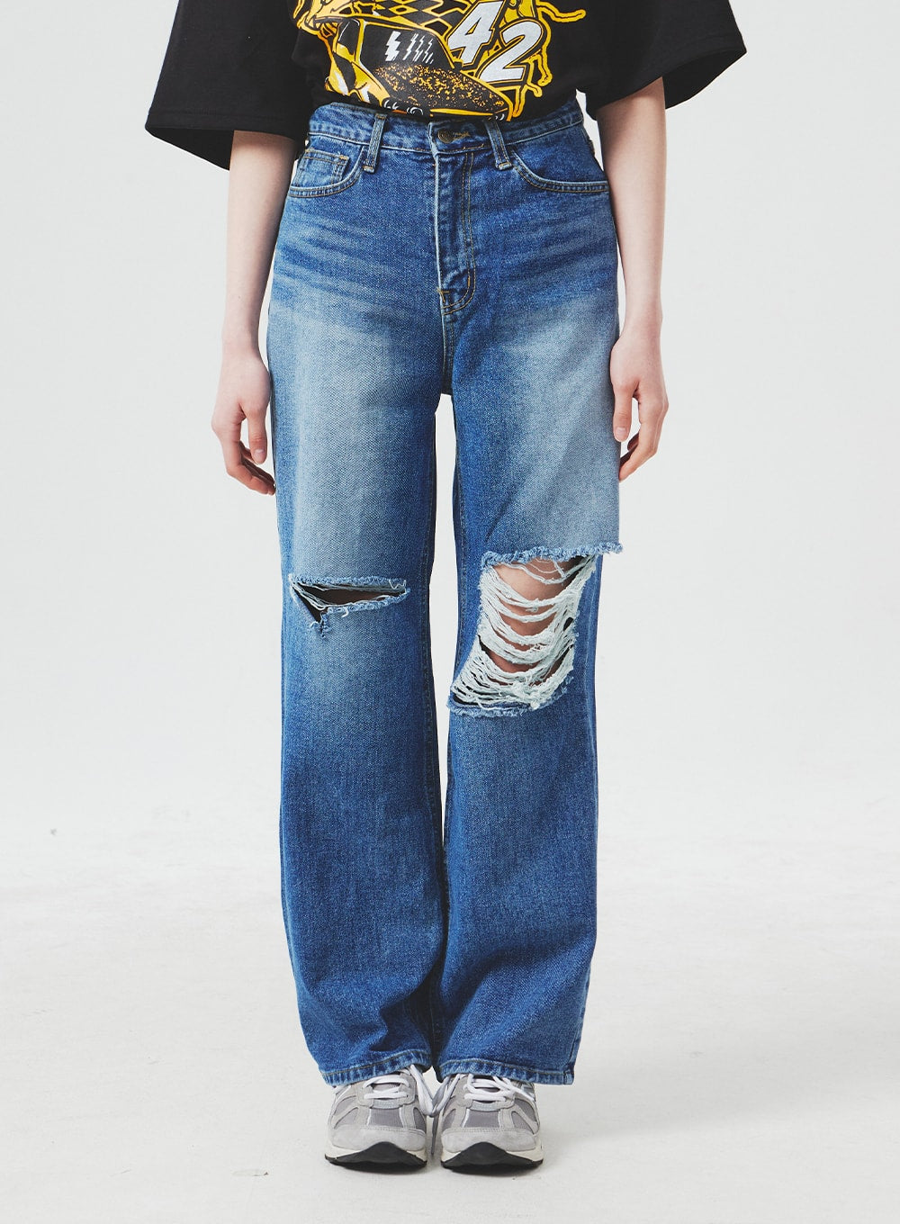 LEWKIN Ripped Knee Blue Jeans BA307 in blue, front cropped shot on model, wide-fit high-rise cotton denim with large destroyed knee rips and fading, paired with black graphic tee and sneakers.