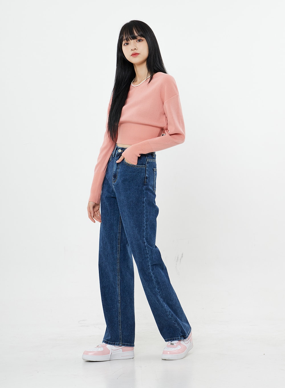 Basic Long Denim Pants BS28 in mid-blue, three-quarter side view on model, straight-fit high-rise wide-leg cotton denim, styled with pink crop sweater and pink sneakers.