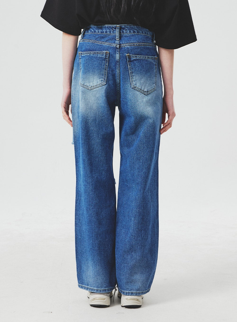 Ripped Knee Blue Jeans BA307 in blue, back view on model from waist to hem, showing two back pockets, faded whiskering, and wide-leg denim cut with subtle distressing at knee.