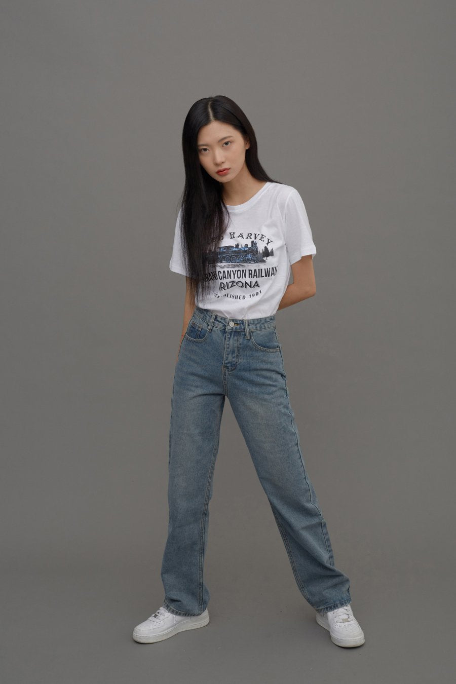 Straight Leg Jeans CM6 in Blue Denim, full-body slight-angle front shot on model, wide stance highlighting straight-leg cut and high-rise waist, styled with white graphic tee and sneakers.