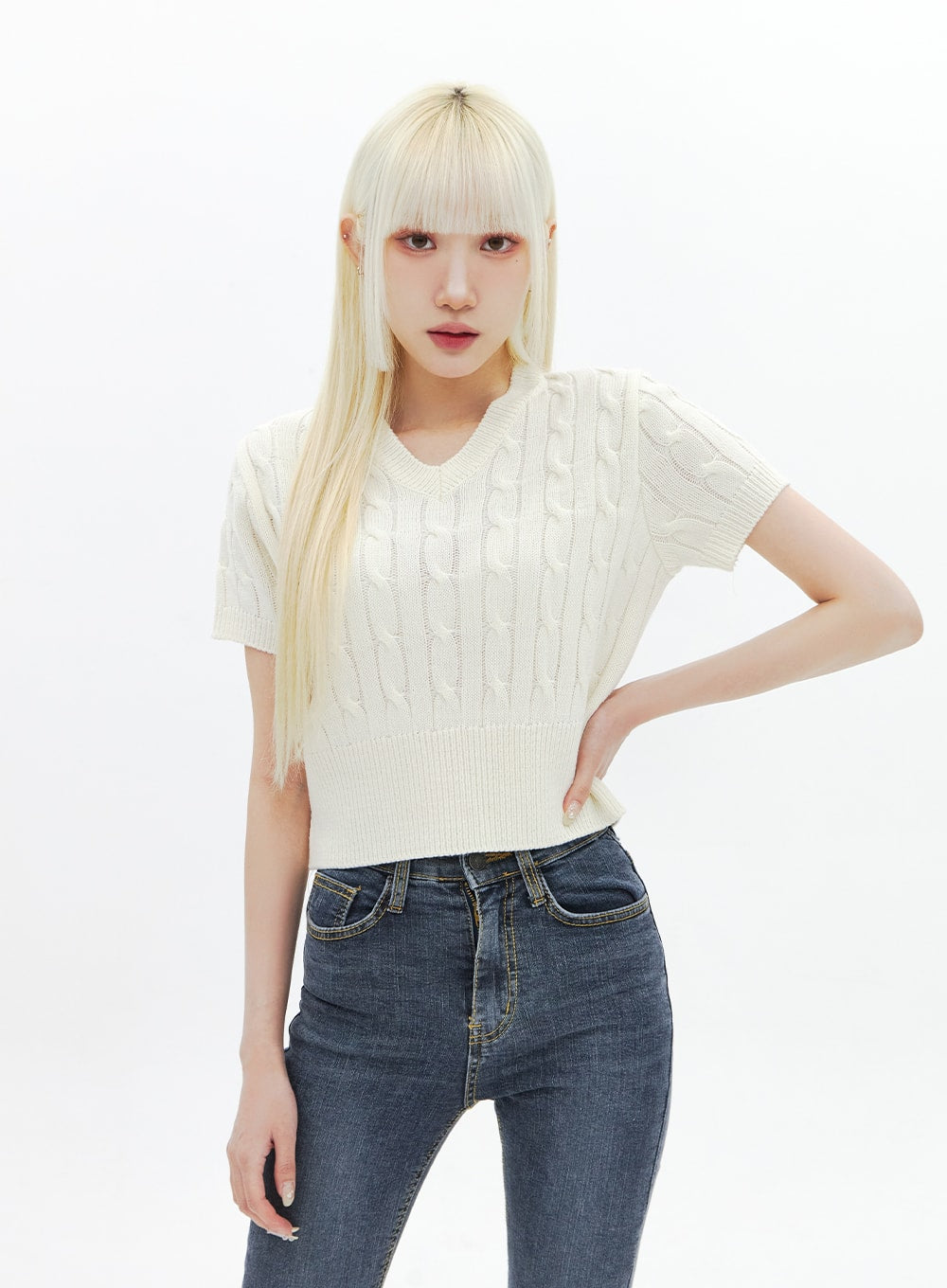 Skinny Ankle Jeans BA321 in dark blue denim, upper-body close-up on model, high-rise waistband and front pocket detail visible, styled with cream cable-knit crop top, casual look.