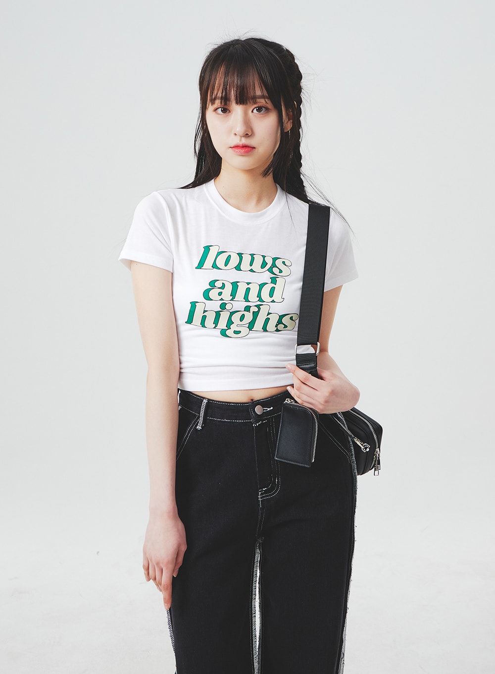 Stitch Detail Jeans BA307 in black, mid-body shot on model holding black crossbody bag, wide-fit denim with visible contrast side stitch stripe at hip, high-waist silhouette.