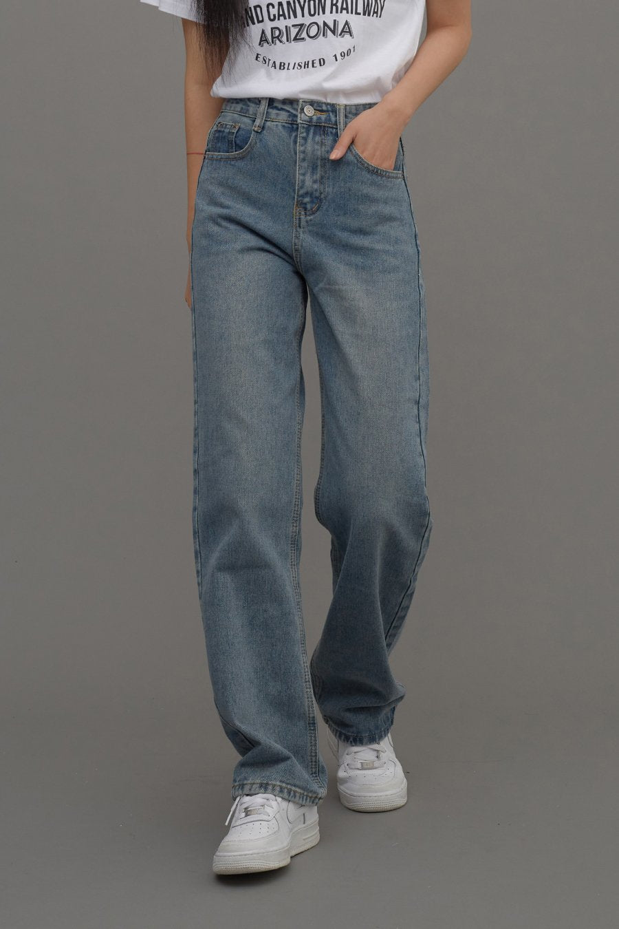 Straight Leg Jeans CM6 in Blue Denim, front three-quarter shot on model, hand in pocket pose highlighting high waist and relaxed straight fit with subtle fading.