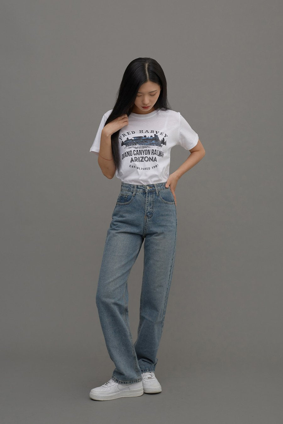 Straight Leg Jeans CM6 in Blue Denim, full-body front shot on model, casual pose with hand in hair, high-waist straight fit falling to ankle, paired with white graphic tee.
