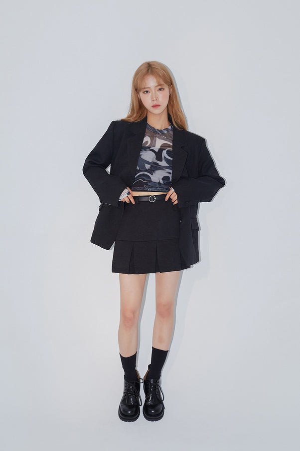 Marble Mesh Top in dark marble print, full-body front shot on model layered under oversized black blazer, slim crop silhouette visible, styled with pleated skirt and lug-sole boots.