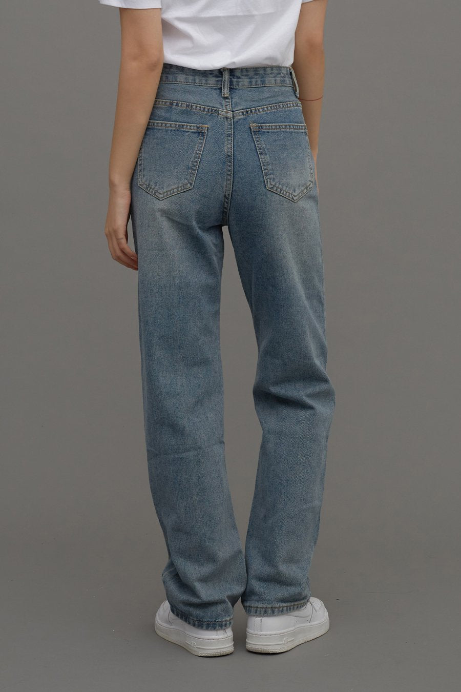 Straight Leg Jeans CM6 in Blue Denim, back close-up on model, showing dual back pockets with contrast stitching and straight-leg silhouette, paired with white tee.