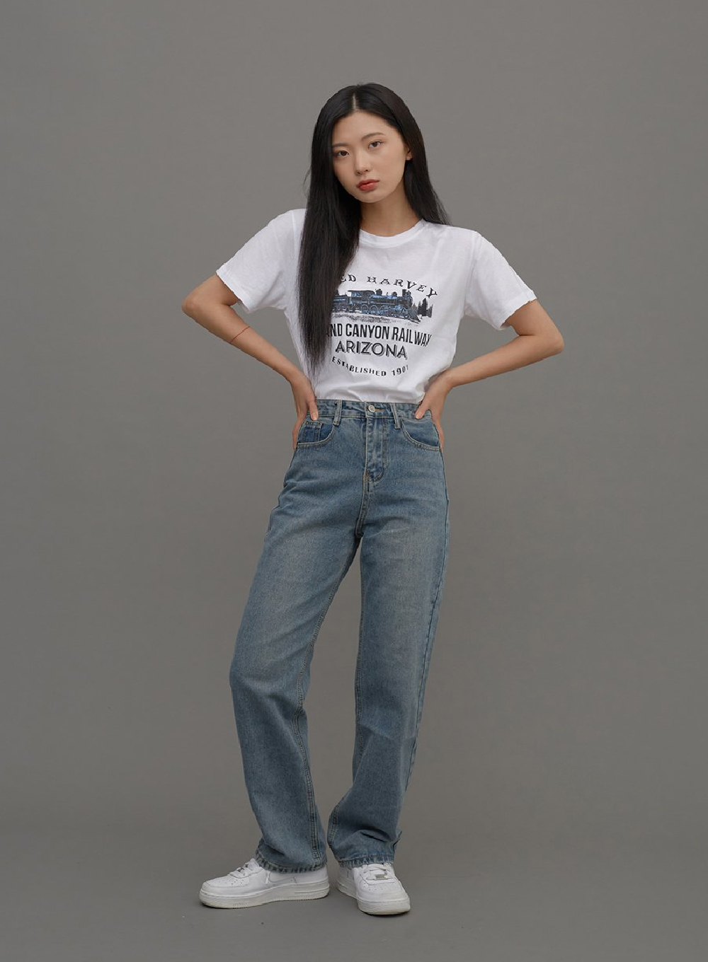 LEWKIN Straight Leg Jeans CM6 in Blue Denim, full-body front shot on model, high-waist cotton straight fit with faded wash, paired with white graphic tee and white sneakers.