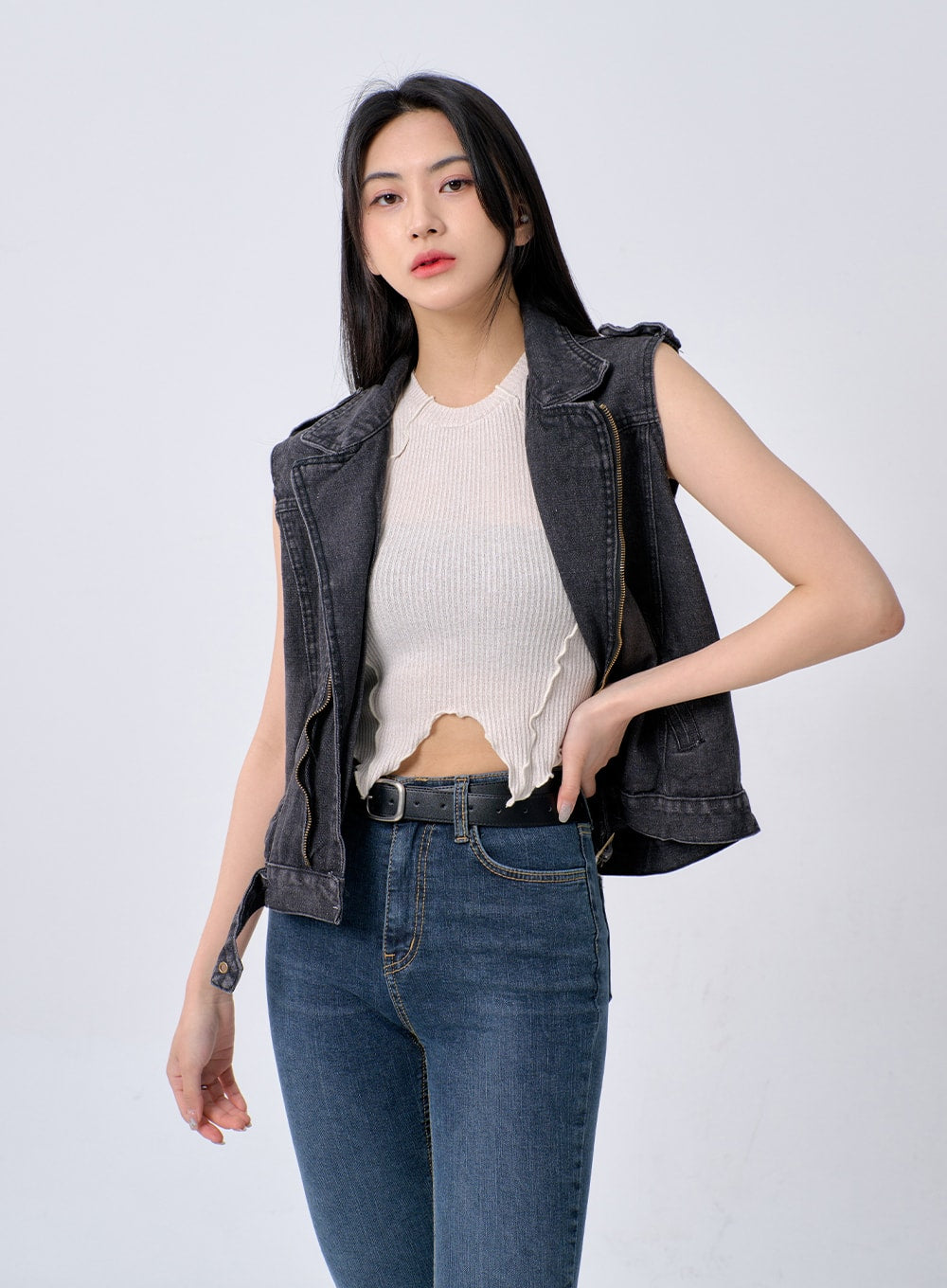 Skinny Ankle Jeans BA321 in dark blue denim, three-quarter front shot on model, high-rise fit with black leather belt, layered under charcoal washed denim moto vest with white knit top.