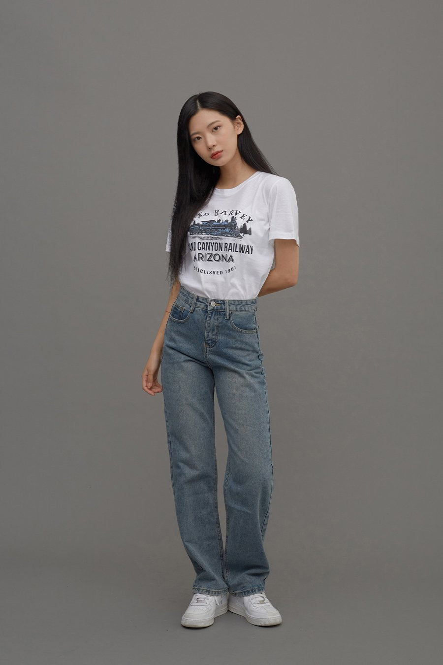 Straight Leg Jeans CM6 in Blue Denim, full-body three-quarter side shot on model, side silhouette showing high waist and long straight leg, paired with white graphic tee and sneakers.
