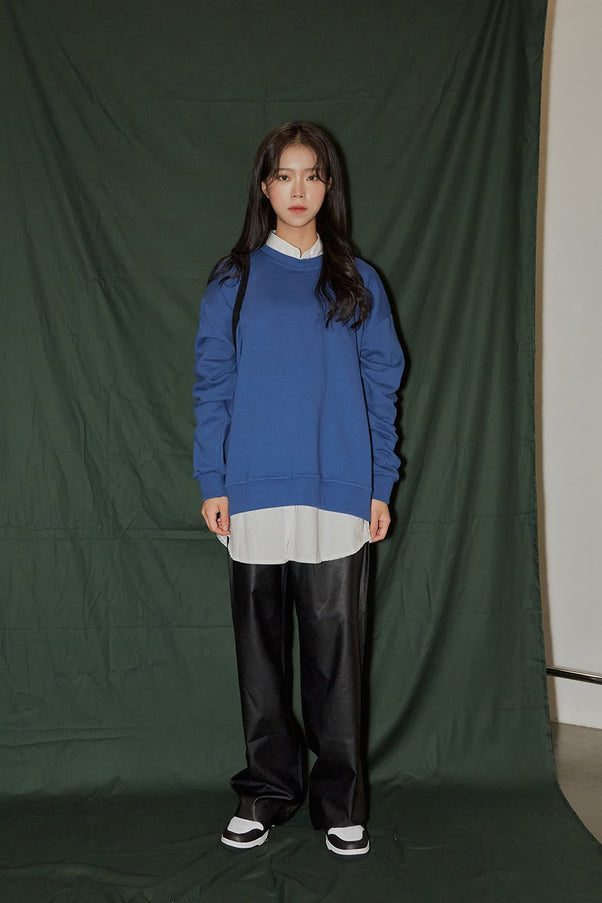 LEWKIN Loose Fit Sweatshirt F6 in blue, full-length front view on model, loose cotton sweatshirt with round neck and ribbed cuffs, layered over white shirt, styled with black faux-leather wide-leg pants and sneakers.
