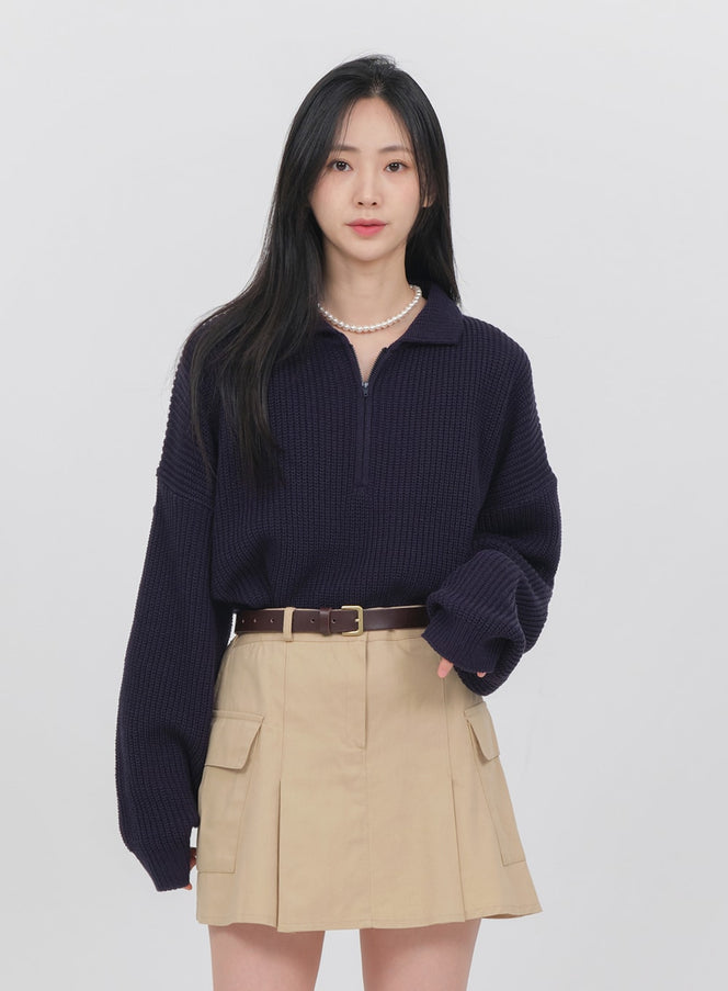 Half Zip-up Knitted Sweat Shirt OA01 in Navy, front full-length on model, loose ribbed knit, polo collar zip detail, styled with beige mini cargo skirt and belt.